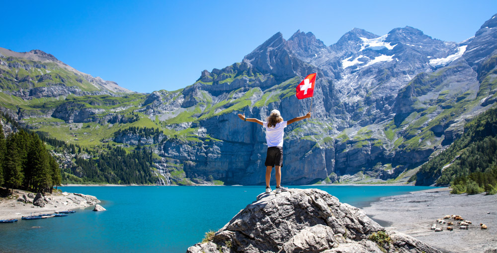 Bern kantonunda Kandersteg'de Oeschinen Gölü kıyısında elinde İsviçre bayrağı tutan bir çocuk